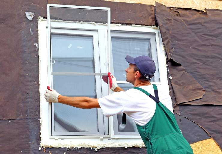Uomo che installa le zanzariere ad una finestra domestica - foto Depositphotos - PalermoLive.it